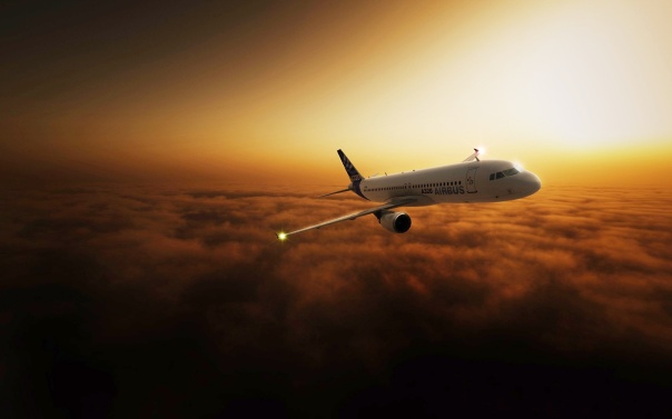 commercial_airline_plane_in_the_sky_after_sunset-wide